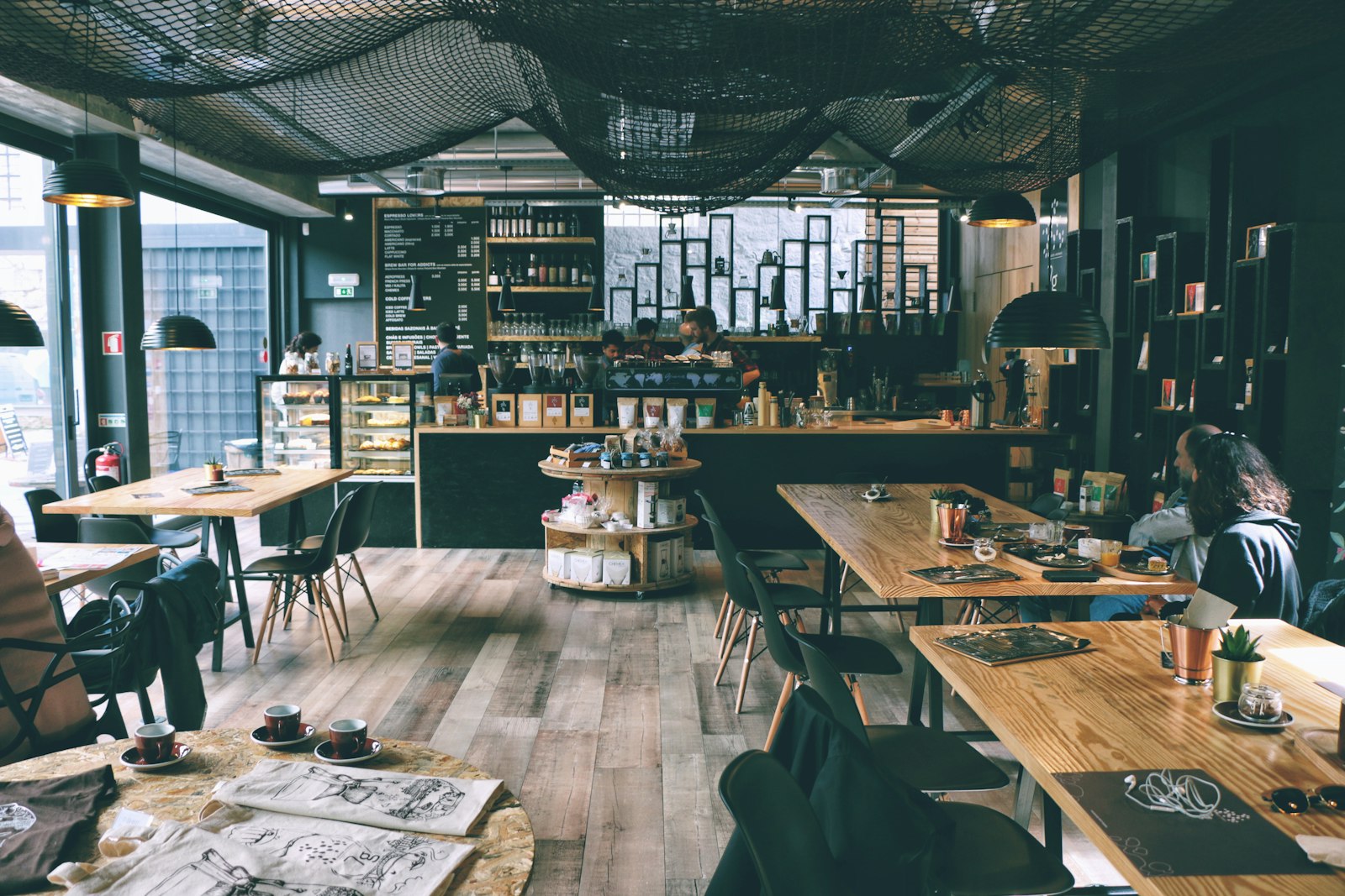 Warm, plant-filled café interior with wooden tables